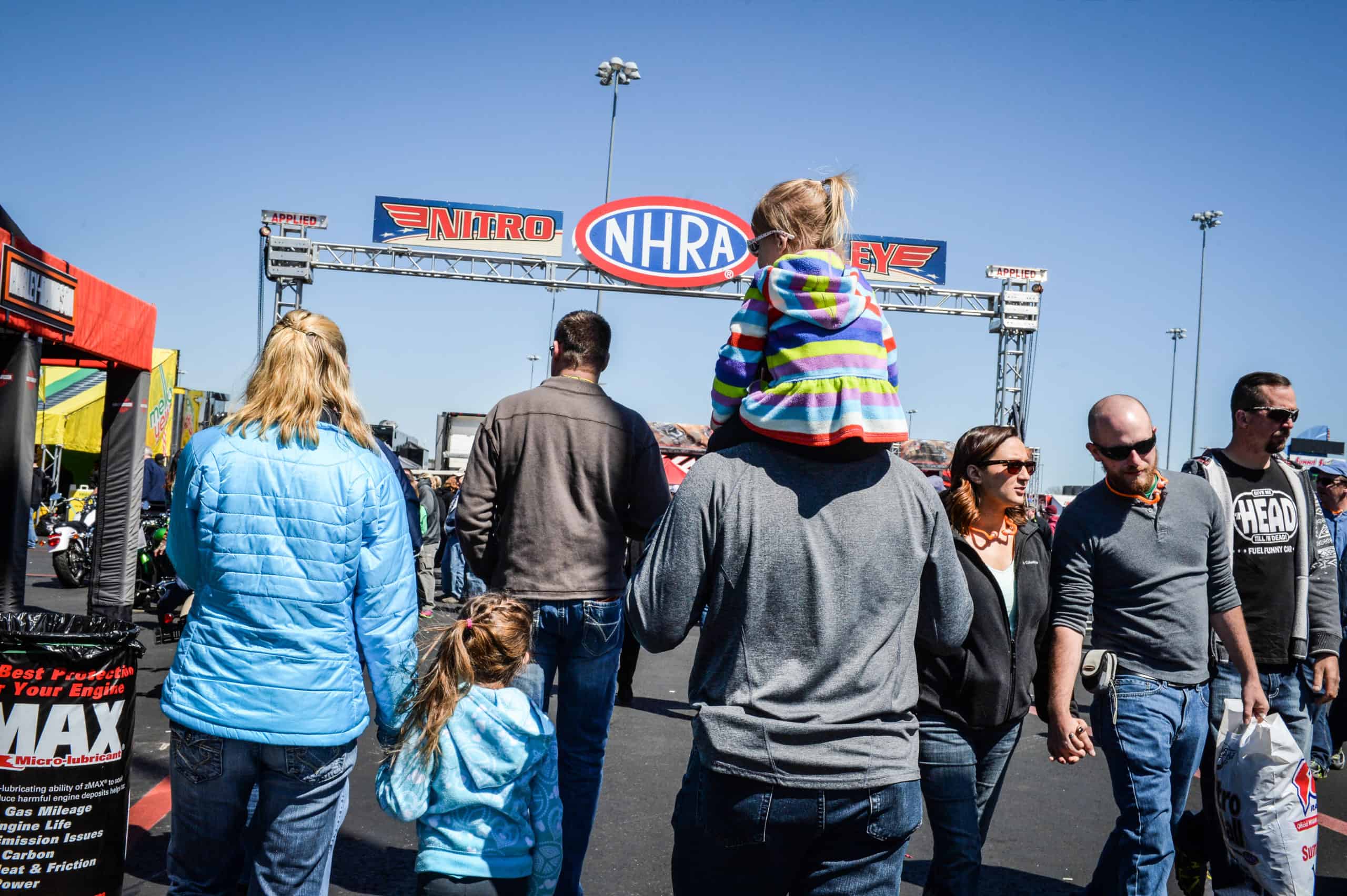 A family enjoys activities in the Nitro Alley Fan Zone at zMAX Dragway