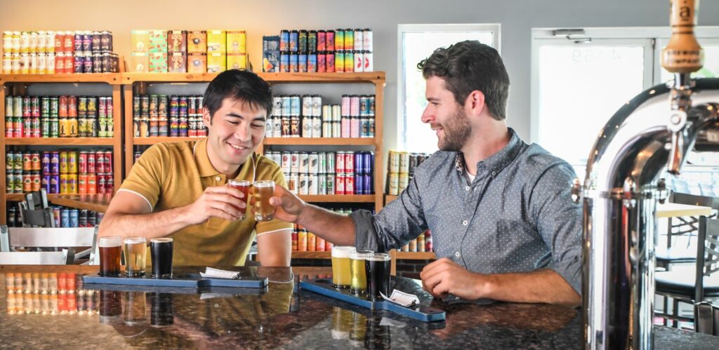 two people toast beer glasses