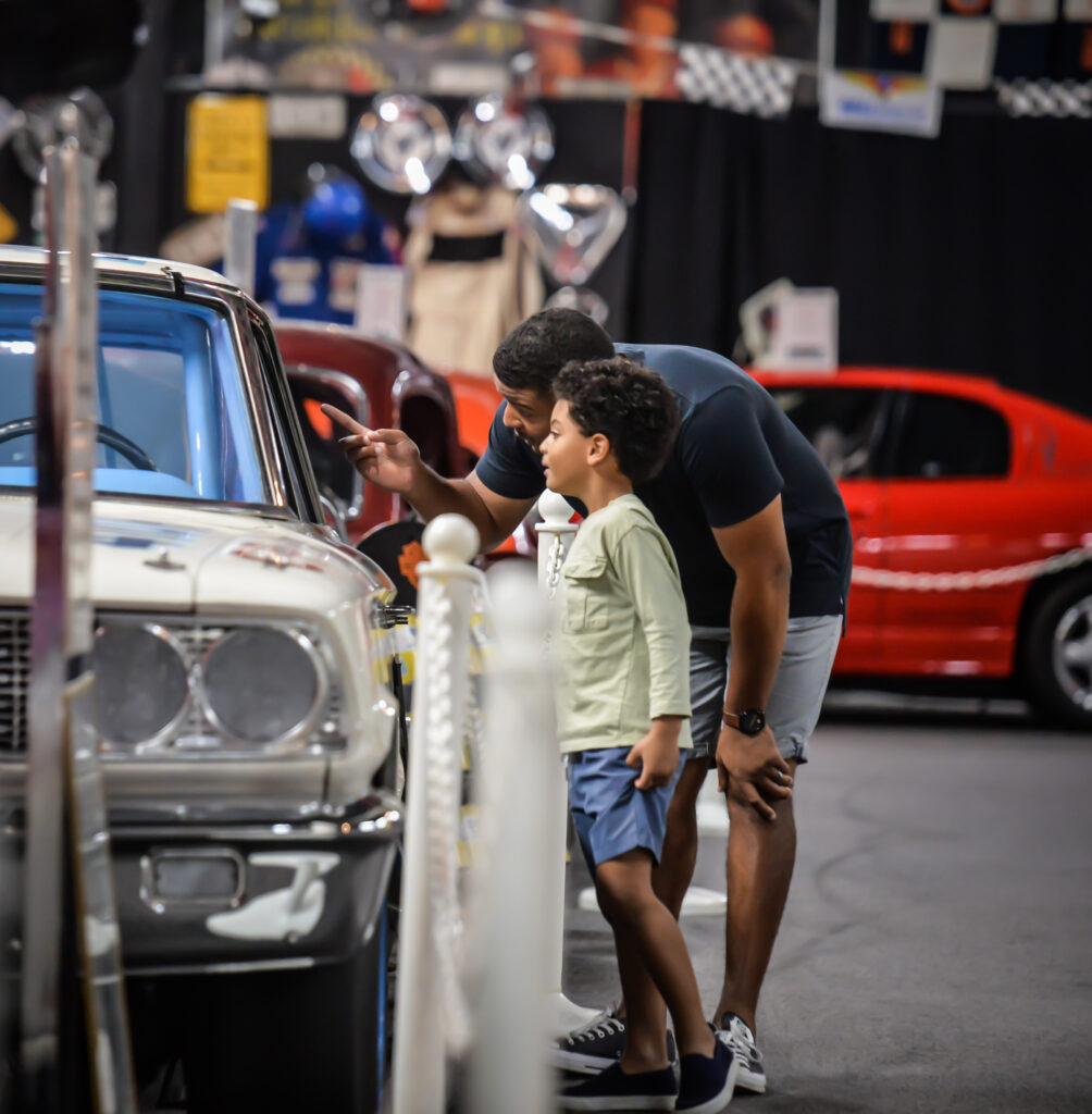 father and son looking at classic car on display
