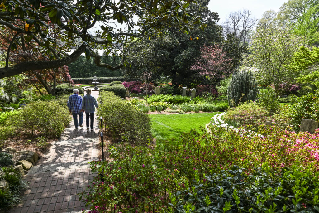 a couple walks through historic garden